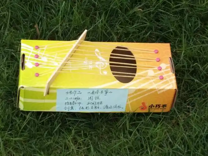 它是由抽纸盒和橡皮筋制作而成的,寓意是纯朴古雅,源远流长.