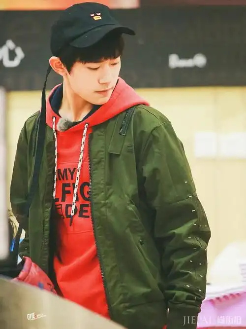 易烊千玺就以红色卫衣打底,搭配绿色外套,整体以绿色为主清爽帅气