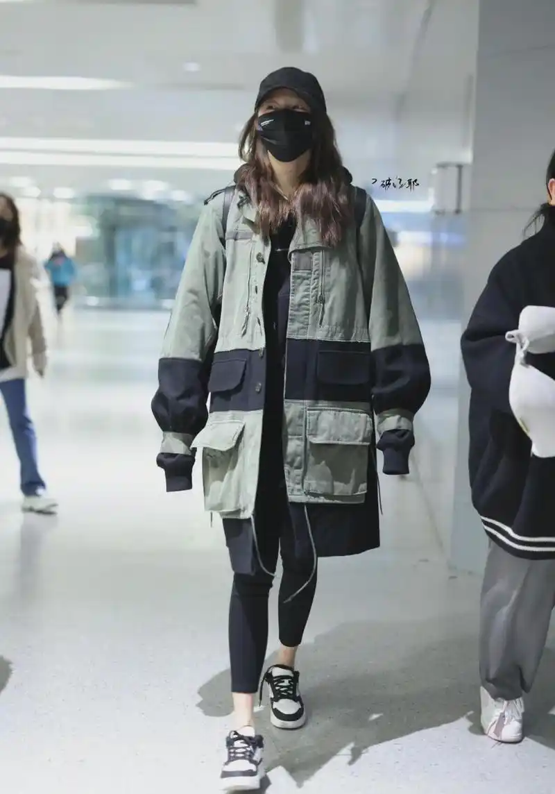关晓彤今日机场私服街拍 中长款大口袋工装外套内搭印花连帽卫衣,九分