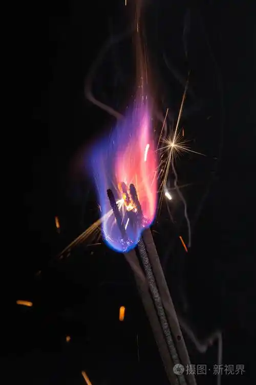 彩色火焰和火花在黑色背景上的特写