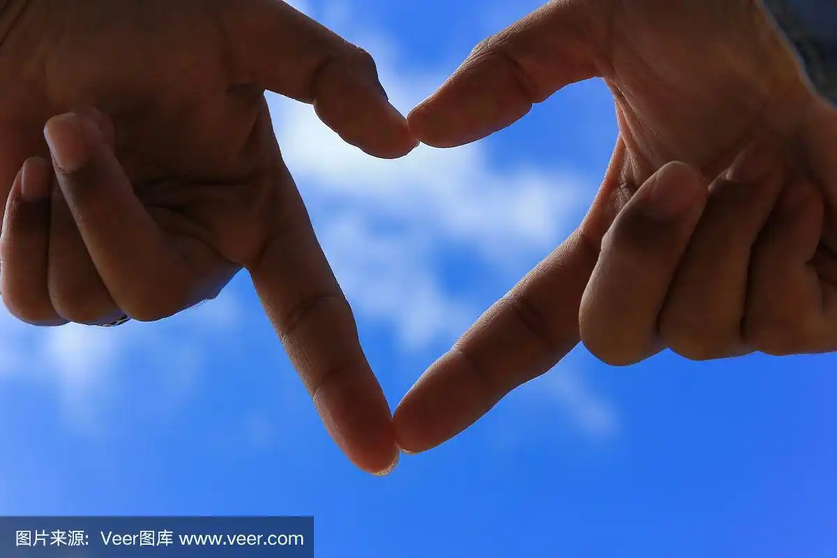 双手在蓝天下做一个心形.爱情和情人节的概念