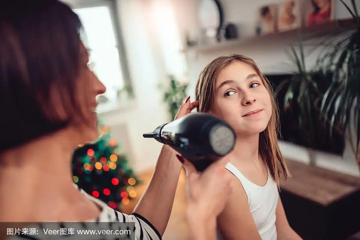 母亲在给女儿吹头发