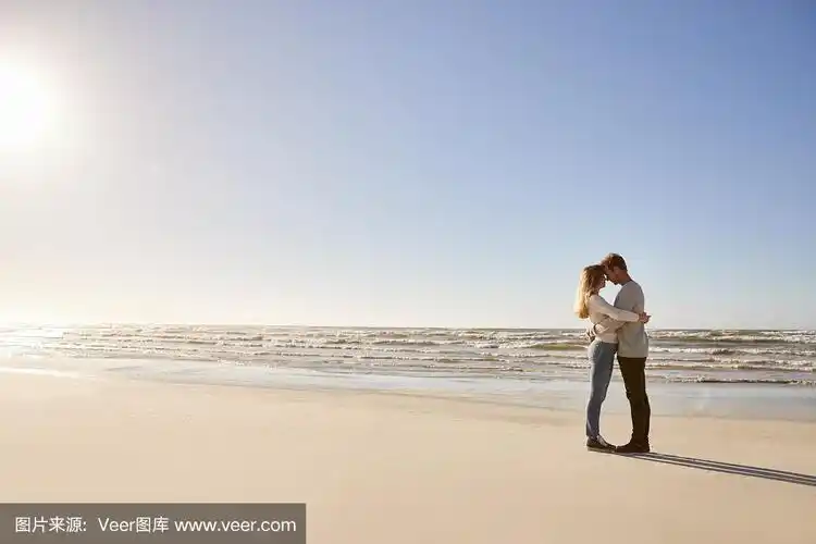 一对浪漫的情侣在冬天的海滩上拥抱