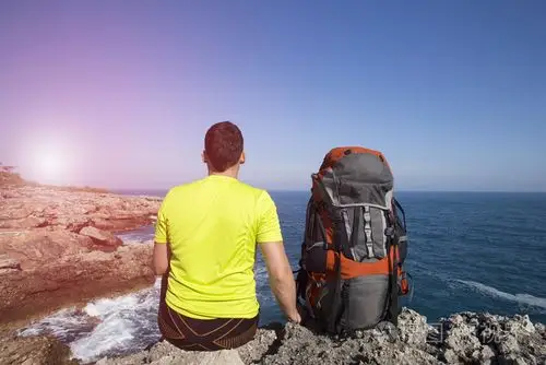 旅行者站在一座山上望向大海