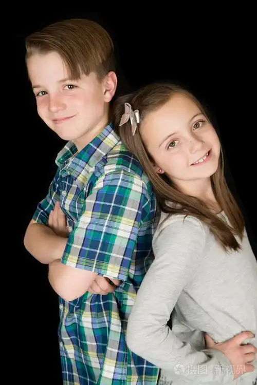 可爱的男孩和女孩的肖像背靠背微笑