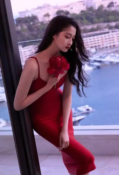 5月25日,关晓彤发文晒一组海边时尚大片,图中,她手持红花,一身红色