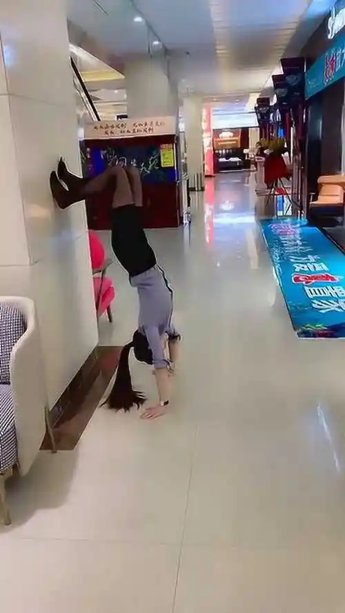 美女身手不错穿裙子玩倒立可惜裙子没掉鞋飞了