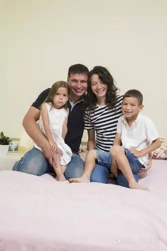 快乐高加索家庭的肖像与两个孩子摆在一起 embra