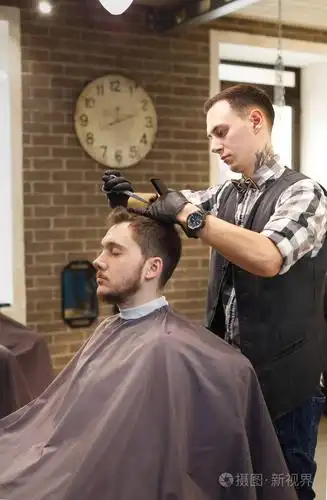 男人的发型师在理发店理发照片-正版商用图片0zrjy8-摄图新视界