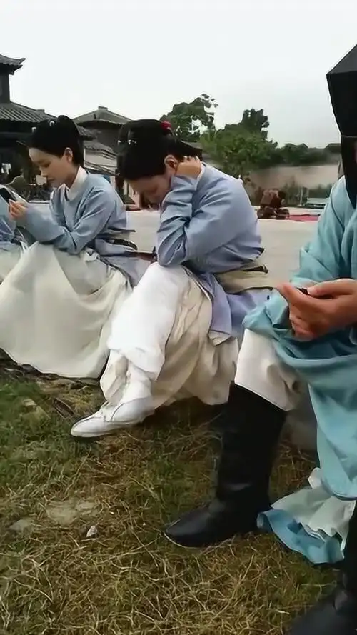 古装剧片场拍戏间歇宫女和侍卫正在玩手机