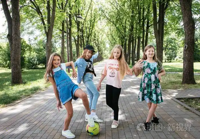 四个小女孩笑着在绿色公园里玩耍以换取一个积极的女学生女友