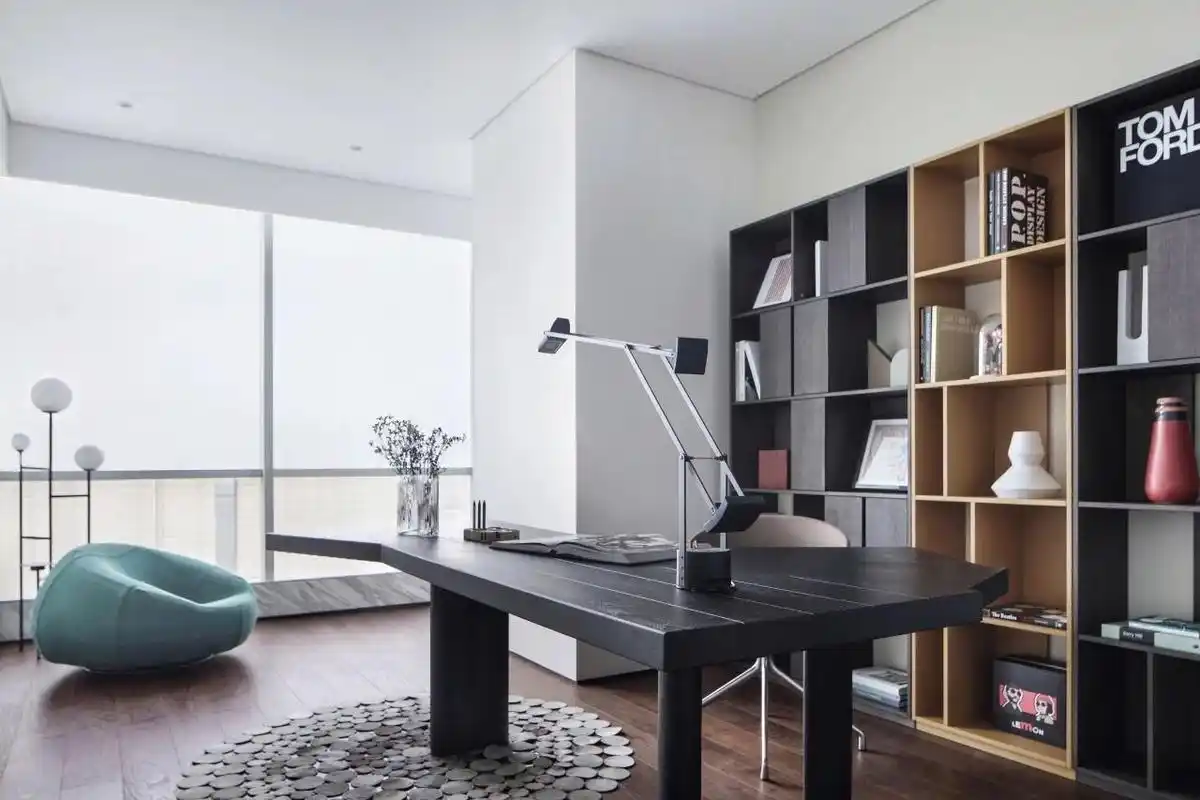 书房浅色背景墙,黑色书桌以及木质书柜相互搭配,空间显得大气简约.