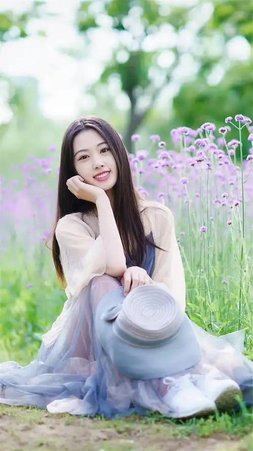 人像摄影紫花旁少女秀发飘飘笑容可掬