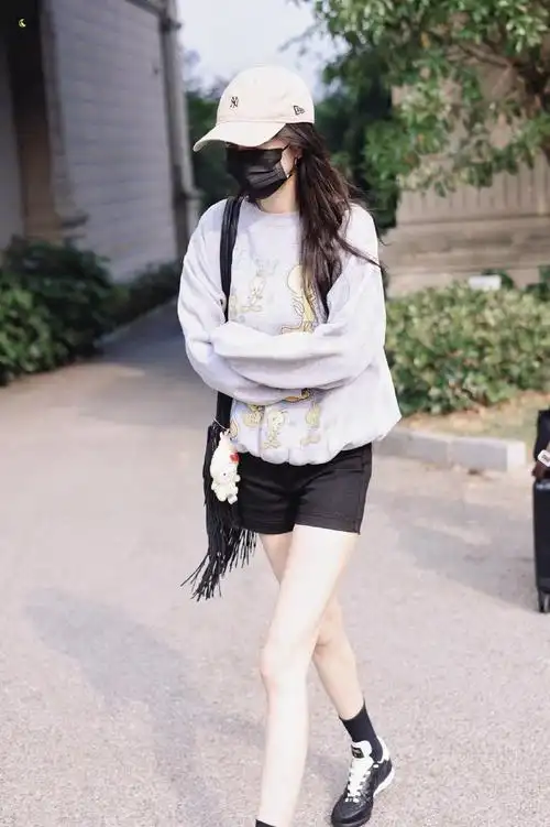 杨幂机场出发造型,灰色卫衣搭配黑色短裤棒球帽,大长腿不要太亮眼～好