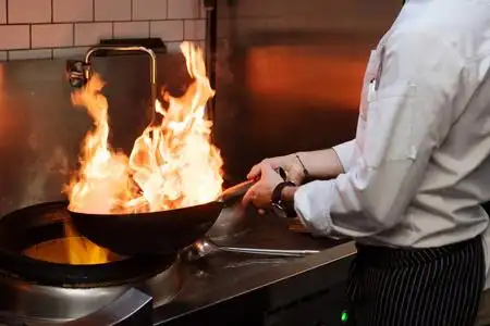 一个人在厨房的火里煮炸鱼.餐厅食品烹饪过程.照片