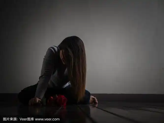 伤心的女人坐在那里哭着,手里拿着红玫瑰.孤独,爱,情感的概念.