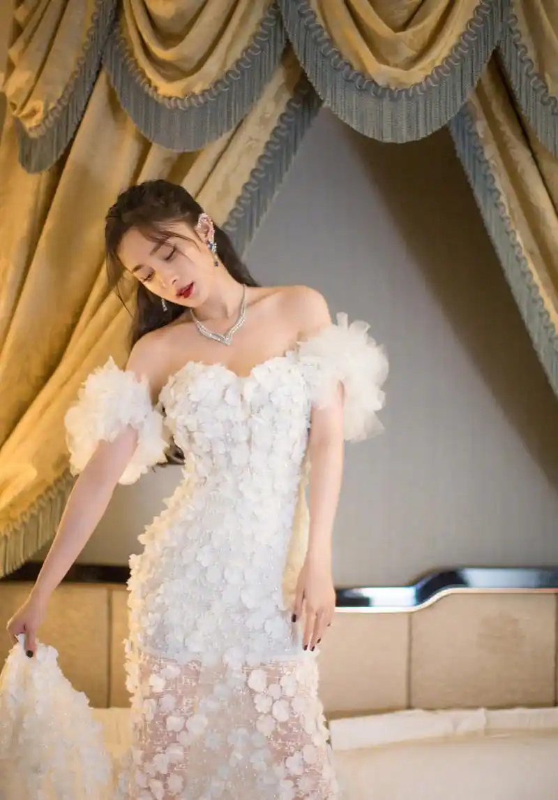 杨幂的穿搭:这次杨幂出席活动时,就身穿了一件白色的露肩抹胸礼服,大