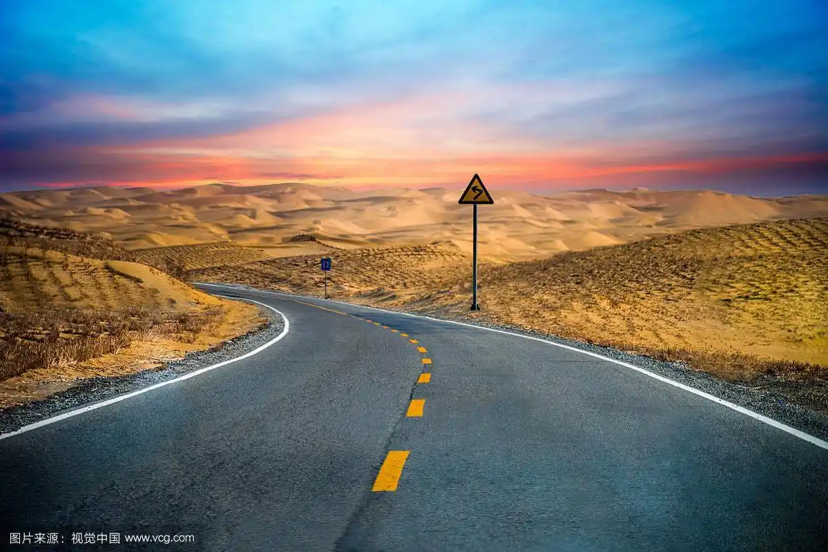 中国新疆塔克拉玛干沙漠傍晚时分沙漠公路转弯处风景