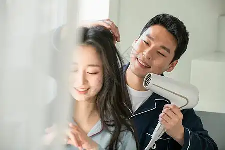 丈夫给妻子吹头发图片素材