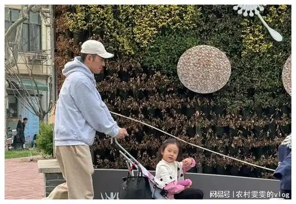 曝42岁李晨上海遛娃女儿五官清秀超像爸推简易婴儿车太低调
