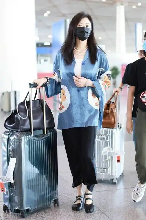 40岁的蒋欣走机场,穿真丝衬衫解开两枚纽扣,戴三层珍珠项链好贵气.