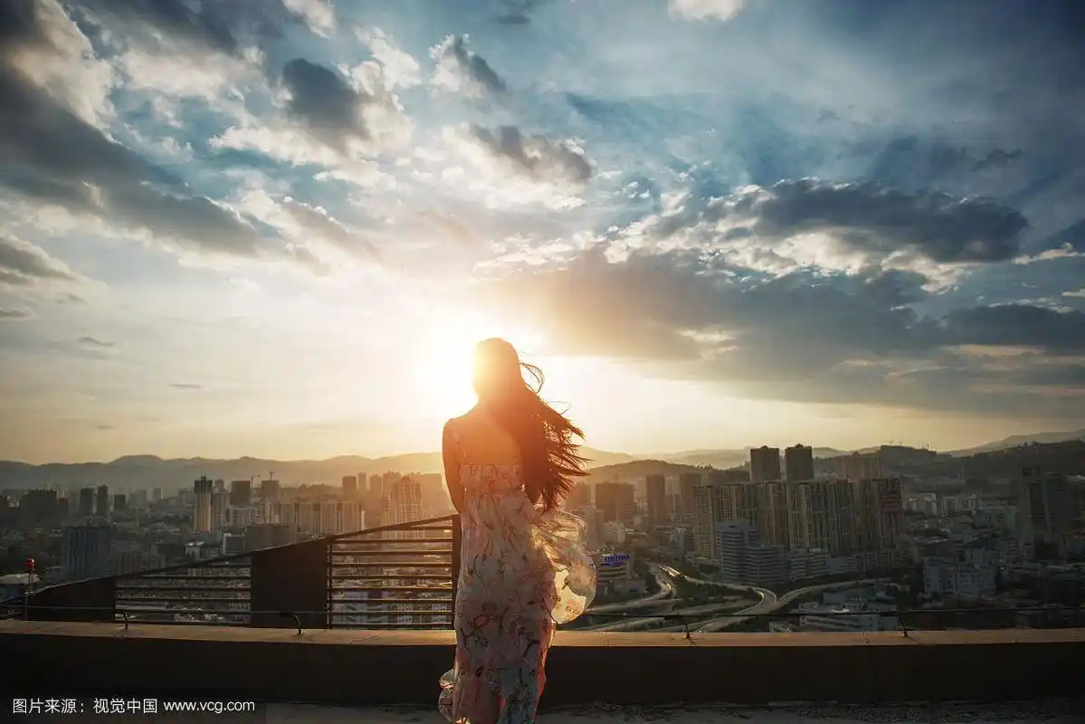 夕阳下美丽的城市女孩背影