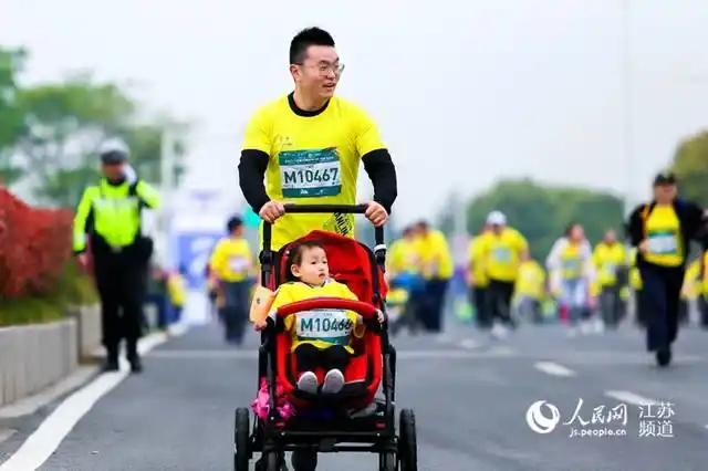 家庭迷你马拉松的参赛选手推着婴儿车参赛