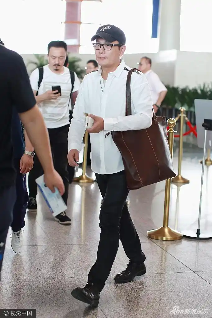 组图:张信哲素颜现身机场 皮肤细腻光滑气色红润