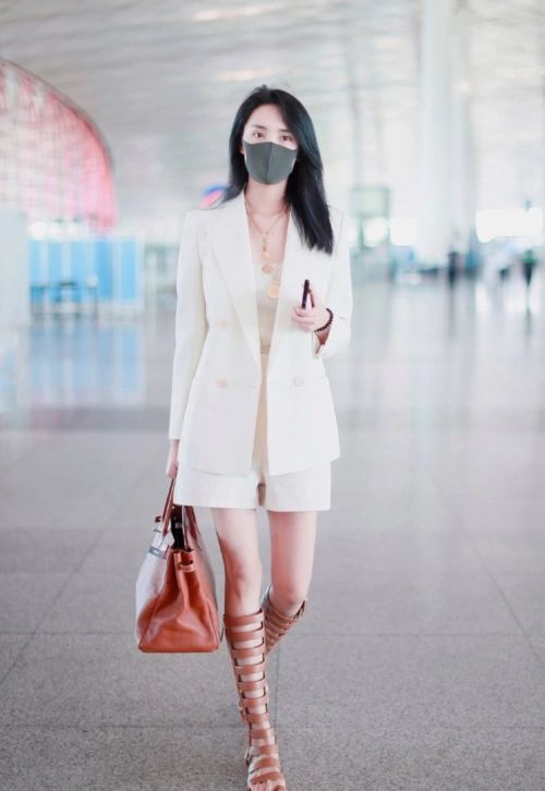 章子怡到了国外特别时髦,穿白色西装配短裤,戴上帽子更有国际范