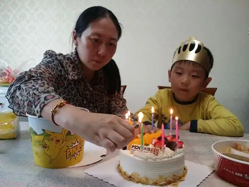 妈妈给儿子乐乐点燃生日焟烛.