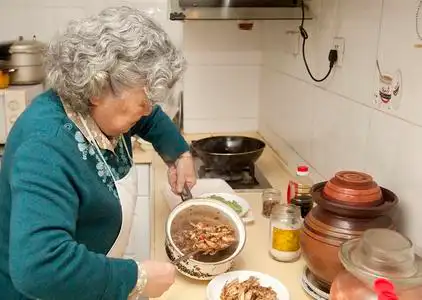 慈祥母亲烹饪的祖母照片