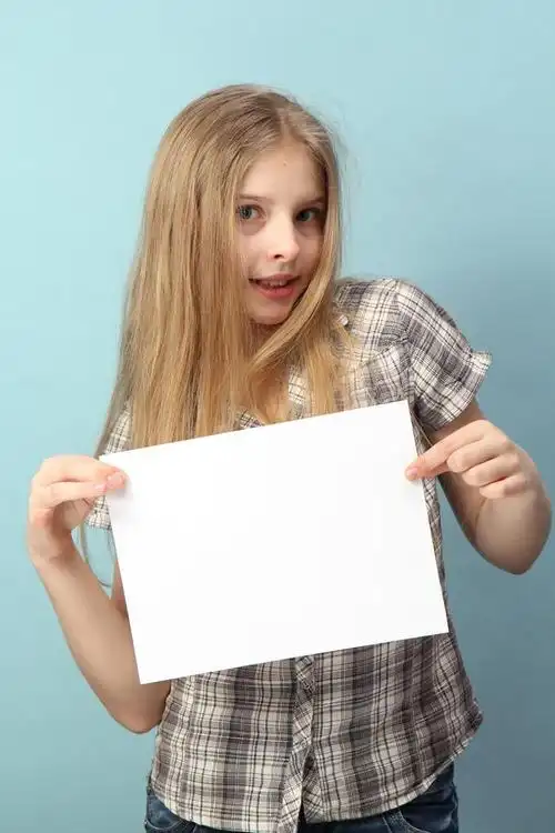 女孩举着空白牌子,一个拿着空白标牌的小女孩