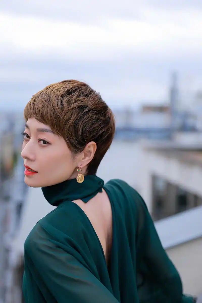 马伊琍现身巴黎时装周看秀现场,松绿色真丝露背衬衫搭配羊毛迷笛裙