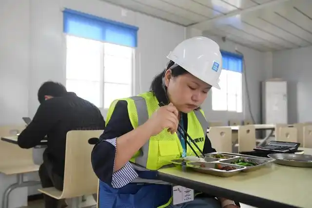 3月19日,在中新南宁国际物流园建设工地食堂,万思佳(右)在吃午饭.
