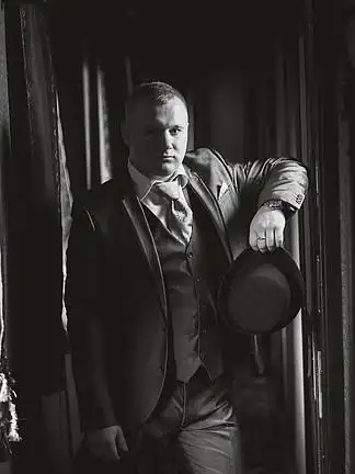 摆在复古火车轿跑车上的年轻绅士的黑白肖像