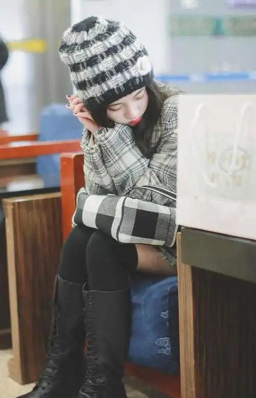 鞠婧祎下身搭配的是黑色的过膝袜和黑色中筒靴,搭配黑色短裙,凸显腿部