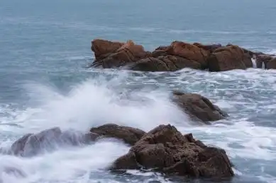 海中的礁石和溅起的白色浪花