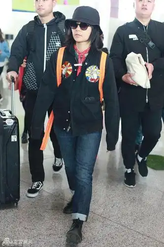 组图:周笔畅值机不忘向粉丝挥手 戴黑色渔夫帽素颜低调