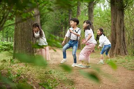 在树林里玩躲猫猫的小朋友图片素材
