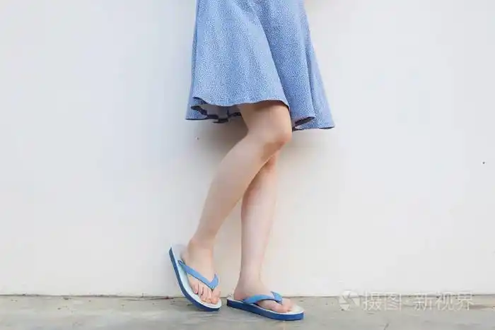 自拍女孩苗条的腿蓝色鞋子和礼服被隔绝在混凝土地板上.