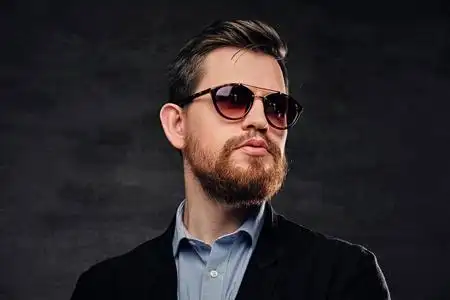 男人为他的女人弹电吉他优雅的胡子的男穿着灰色 t恤衫的红发胡子男