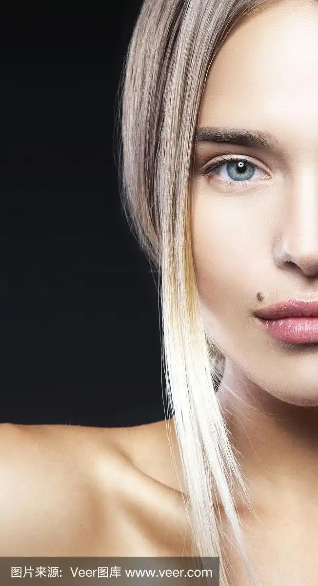 迷人的美丽模特女孩的部分脸与美人痣附近的嘴唇.