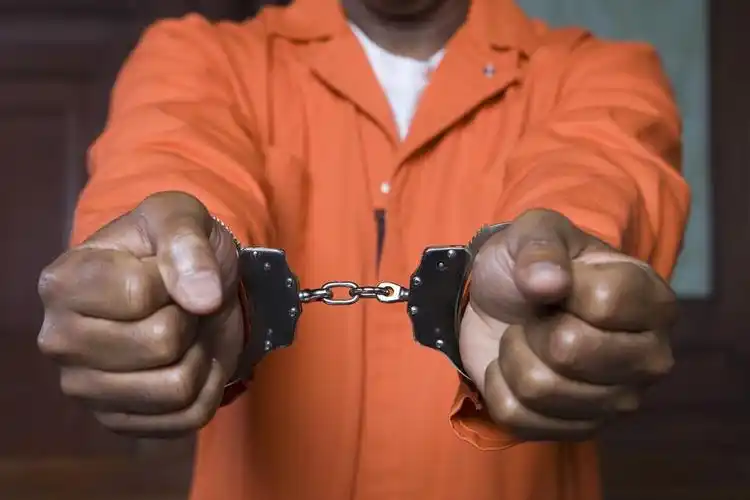 戴着手铐的刑事,罪犯的戴着手铐的双手的特写