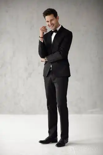 穿着黑色西装的英俊微笑男人看着摄像机