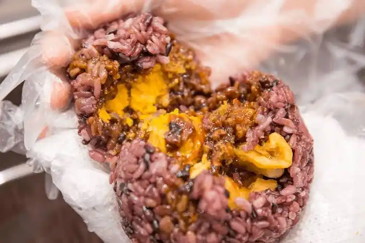 他们家每一个饭团严格按照顺序来的,一层糯米,脆油条,秘制肉糜,肉松