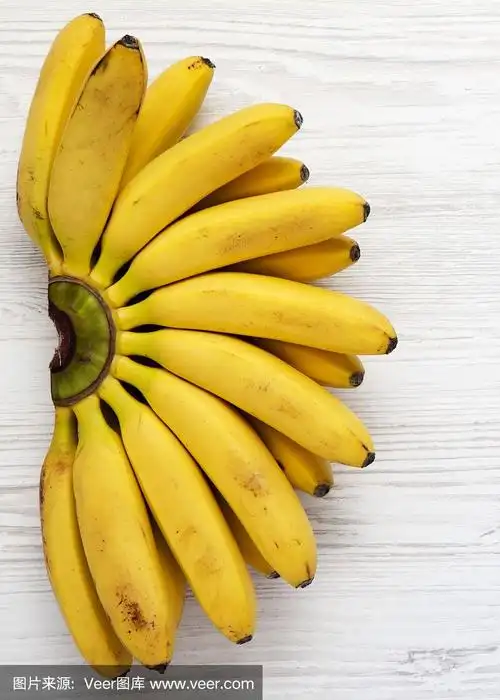 俯视图,白色木质背景上的小香蕉.从上面看,平躺在头顶上.